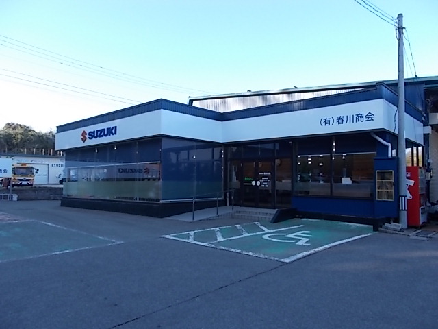 スズキの看板が掲げられた、青と白を基調とした店舗の外観