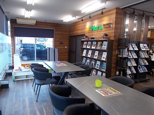 大きな窓に面した、商談用のテーブル席が複数ある明るい店内