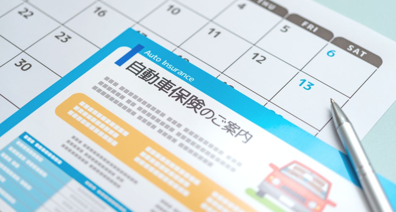 カレンダーと「自動車保険のご案内」と書かれた書類
